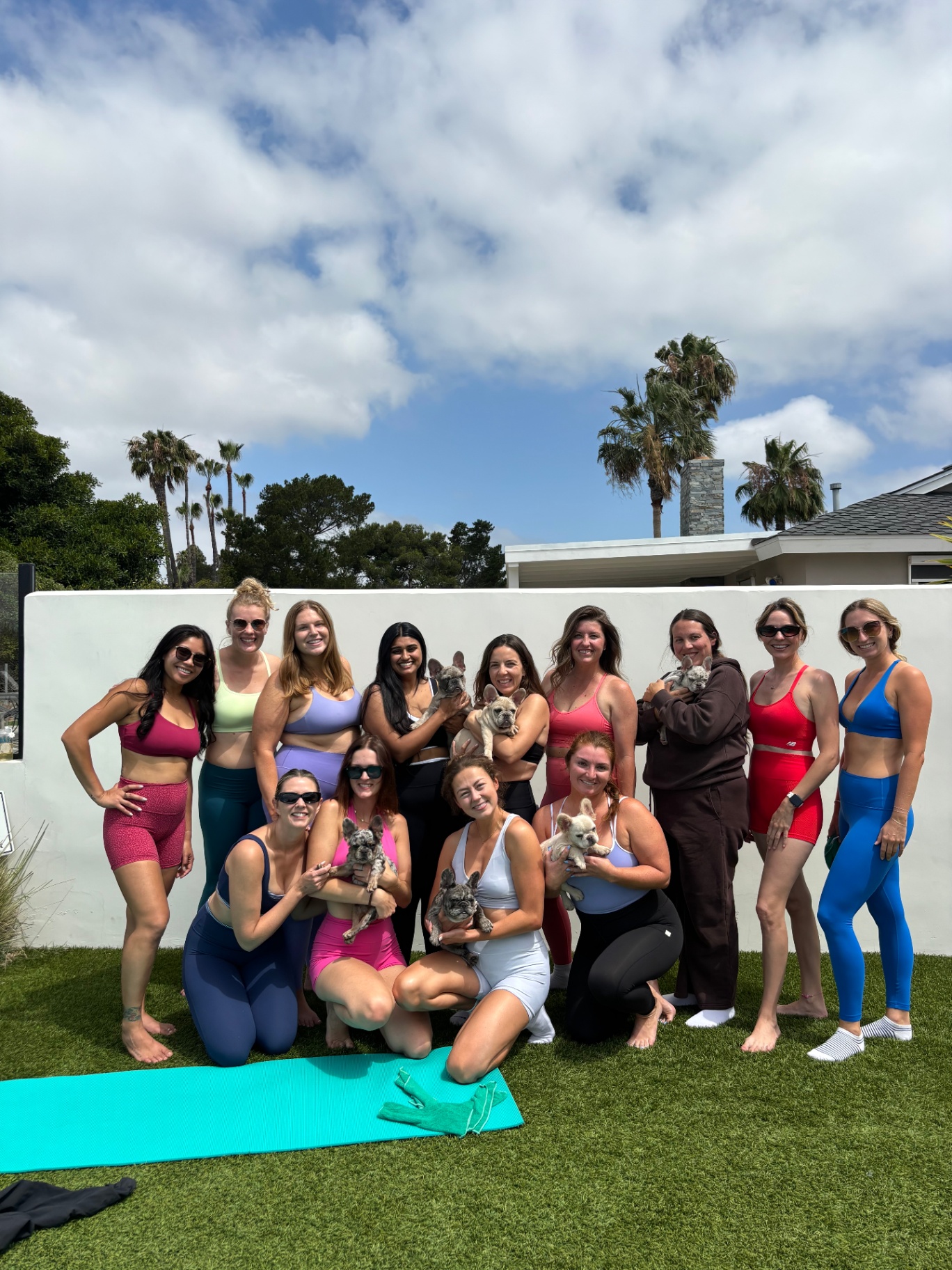 San Diego rooftop group with palm trees holding French bulldog puppies