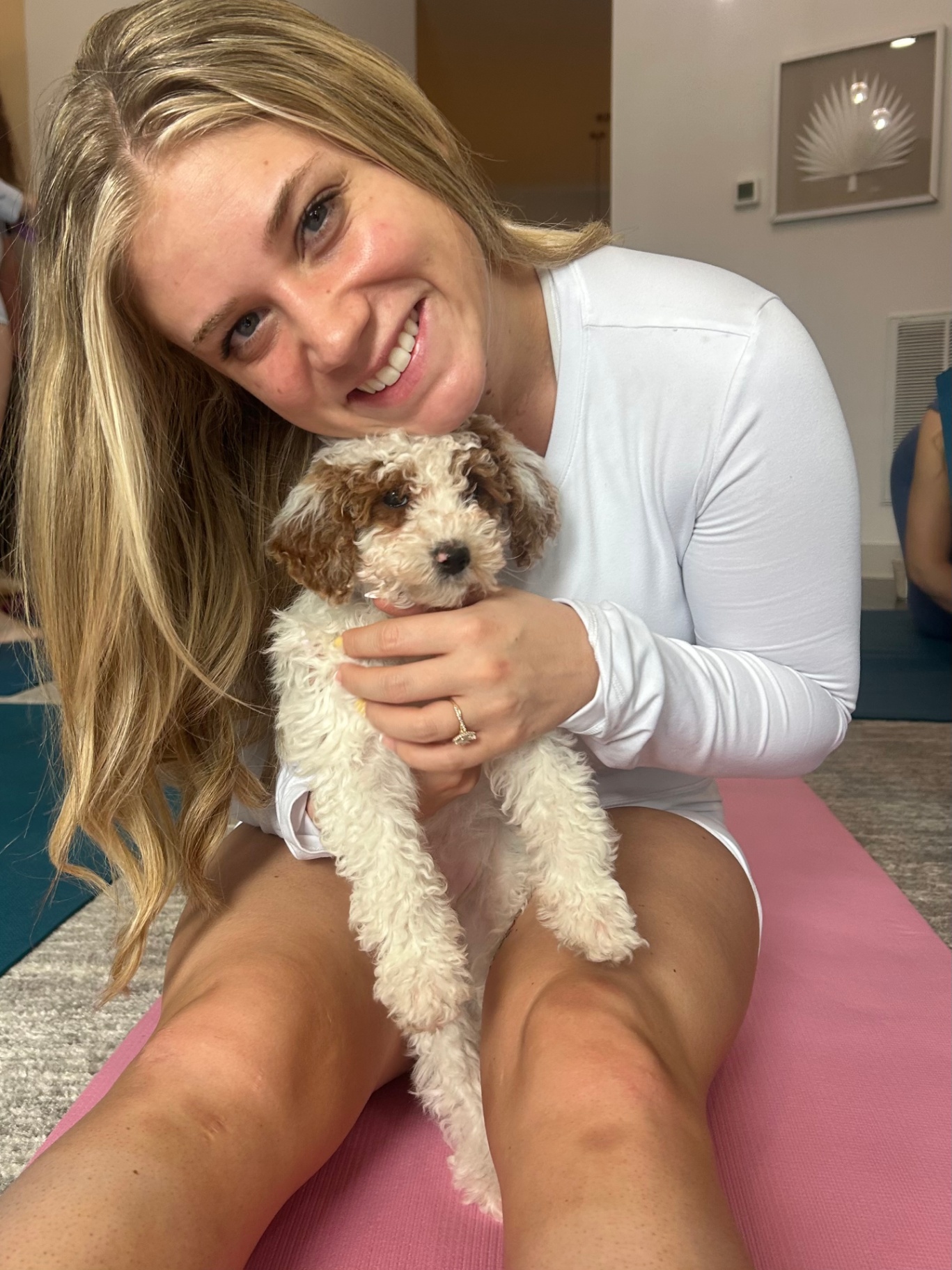 Guest cuddling a puppy for a close portrait in class
