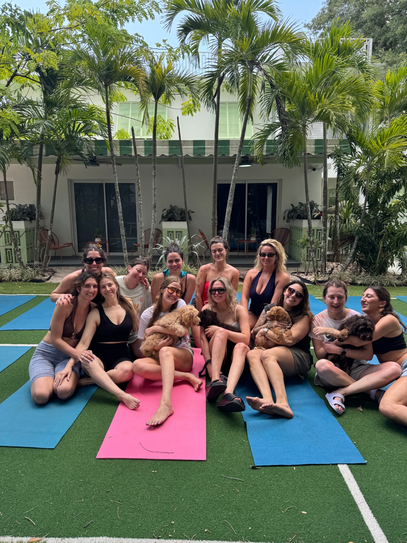 Miami puppy yoga group sitting together with puppies on the mats