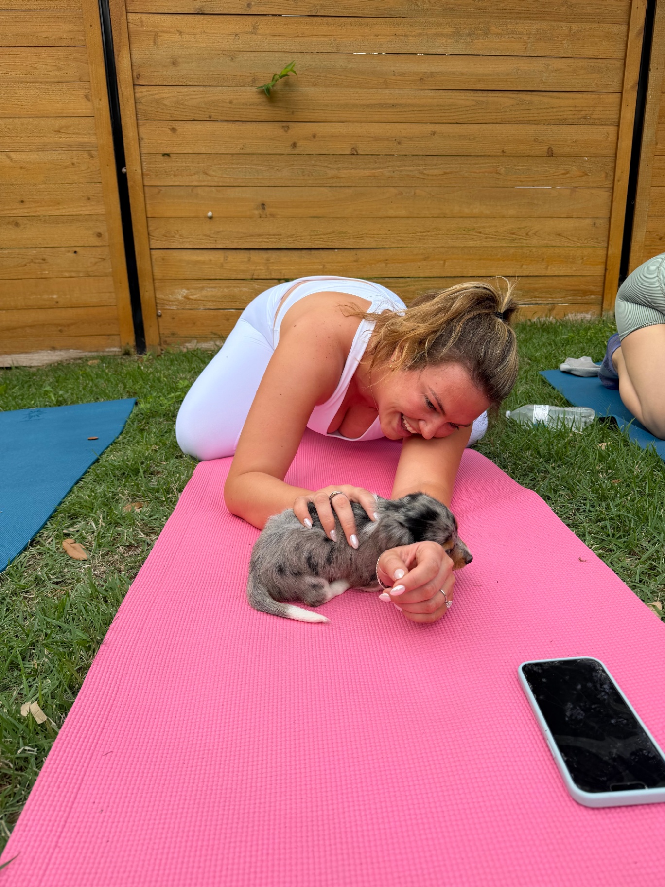 Guests holding puppies overhead during an outdoor class