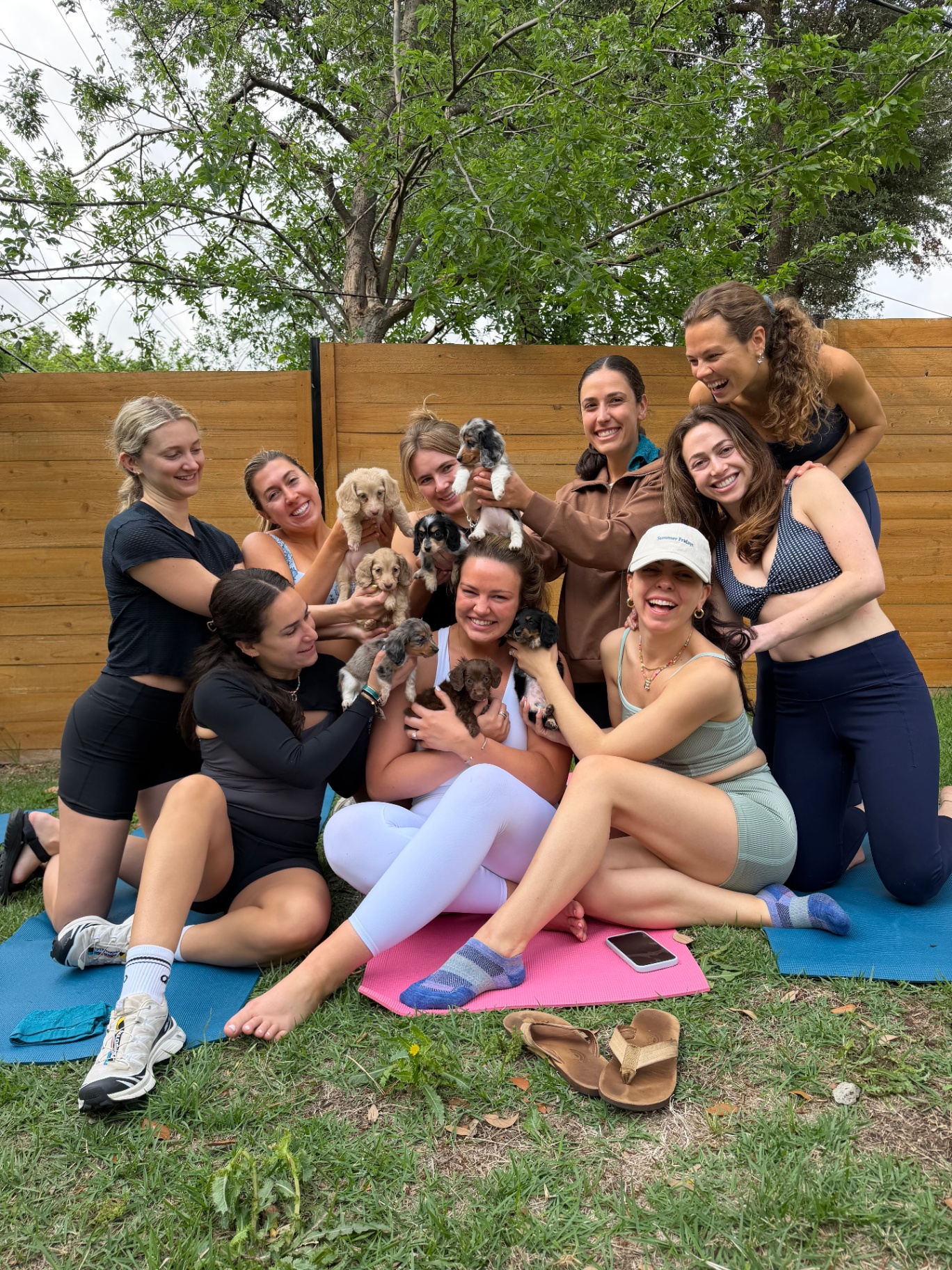 Yoga students laughing as puppies run around
